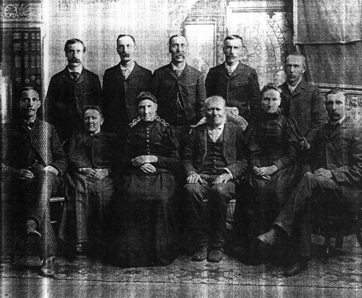 A nineteenth-century family photograph of a seated older couple with their grown children standing behind them.